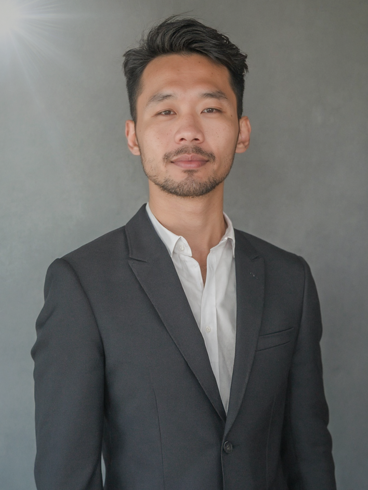 VIP Events, wearing a dark tailored blazer and white shirt, short hair, clean-shaven, neutral background, confident expression,